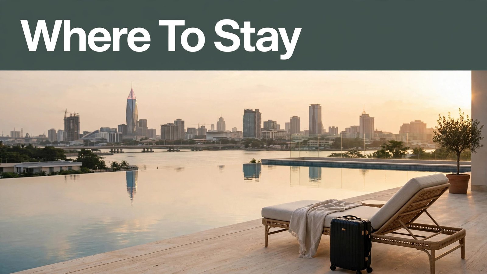 A hotel pool terrace overlooks Victoria Island at golden hour, with a suitcase beside a lounger.