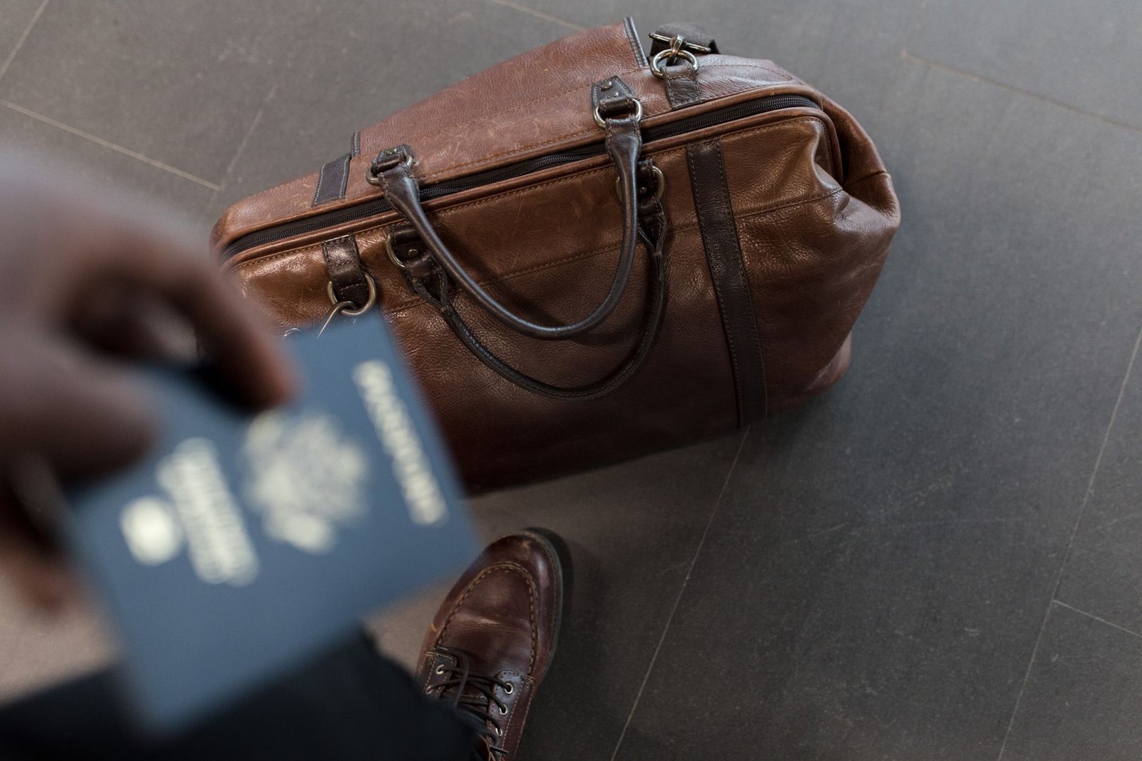 Passport and travel documents in a leather bag at an airport
