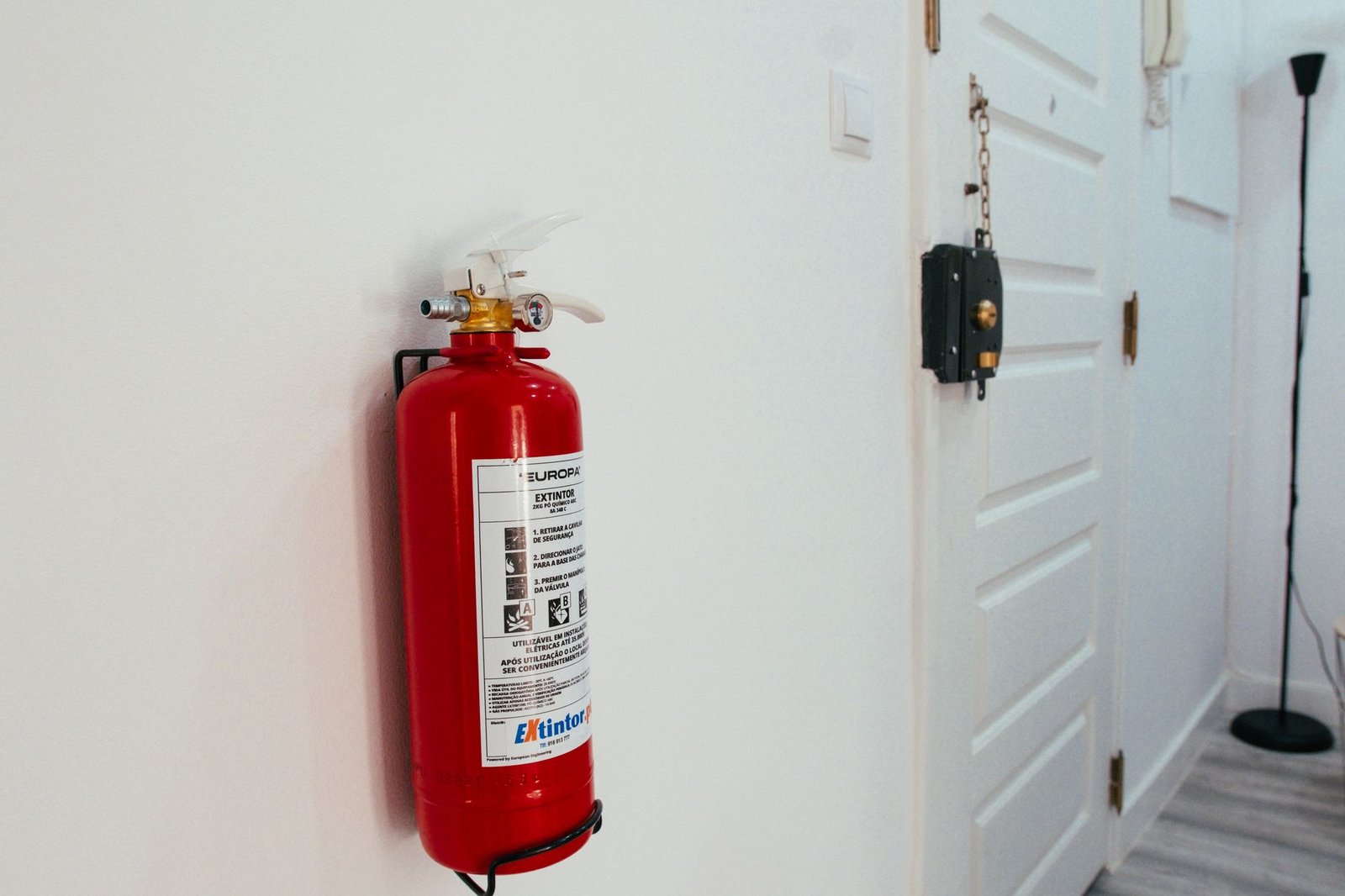 Fire extinguisher mounted in a modern apartment hallway