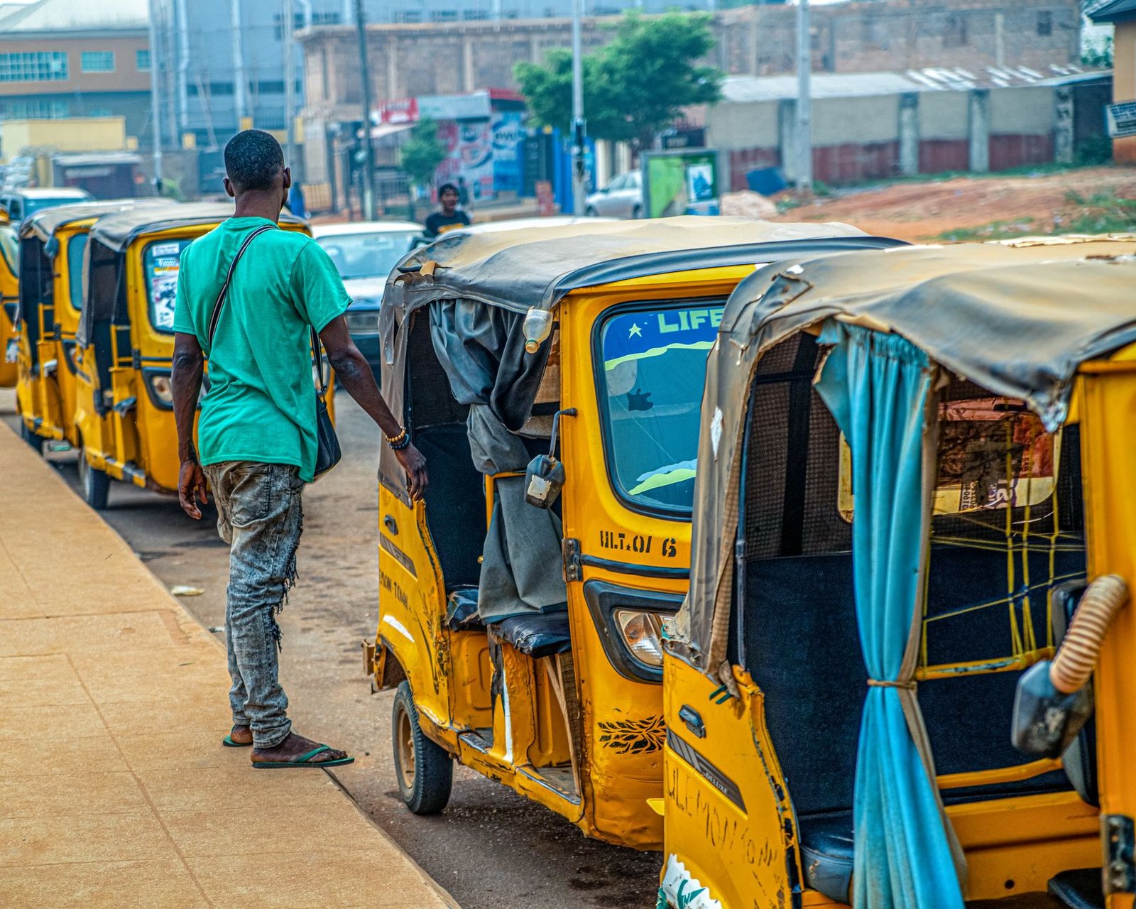 Yellow rickshaws lined up on a Lagos street