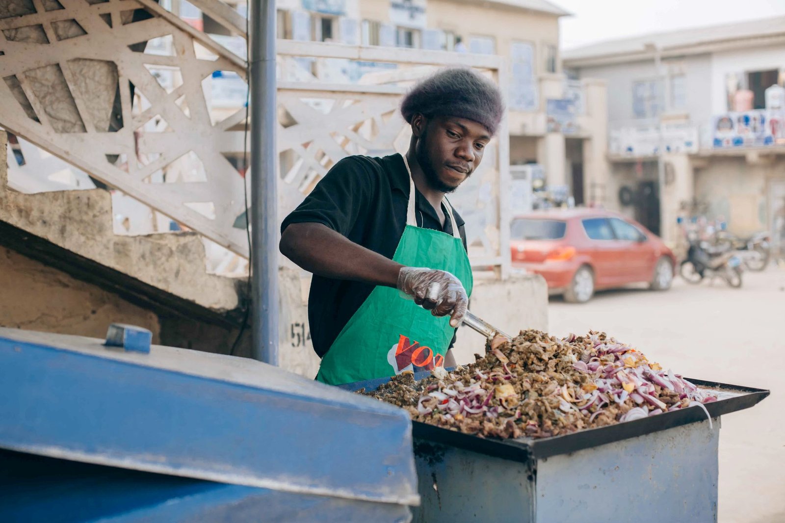 Street vendor preparing jollof rice on a busy urban street