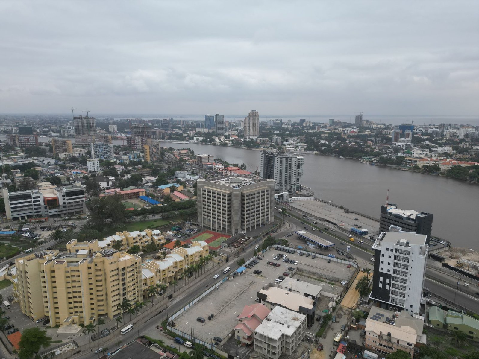 Aerial shot of Lagos cityscape with modern buildings by Lagos Lagoon under an overcast sky