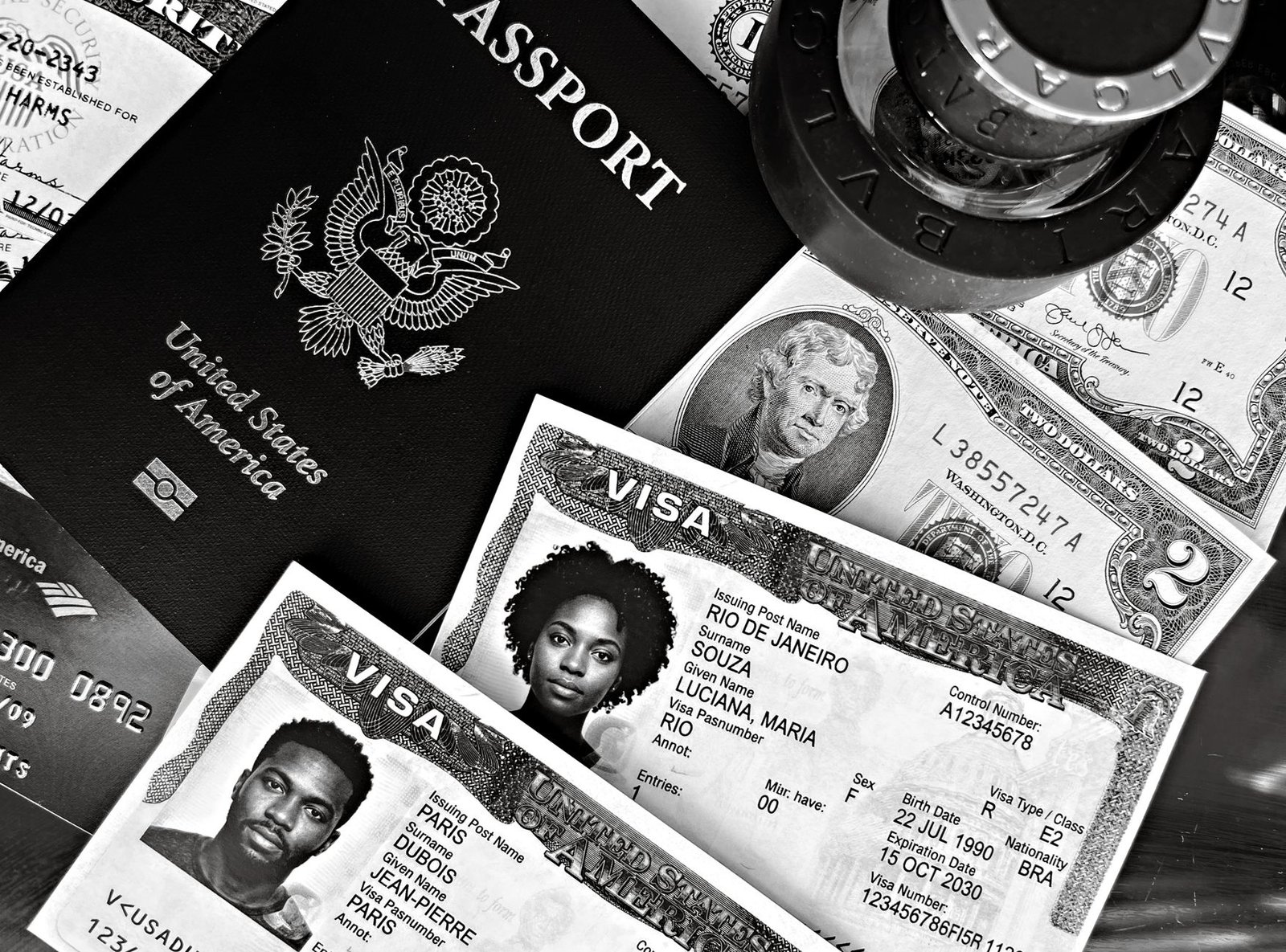A black and white composition of a US passport, visas, and currency, showcasing travel essentials.