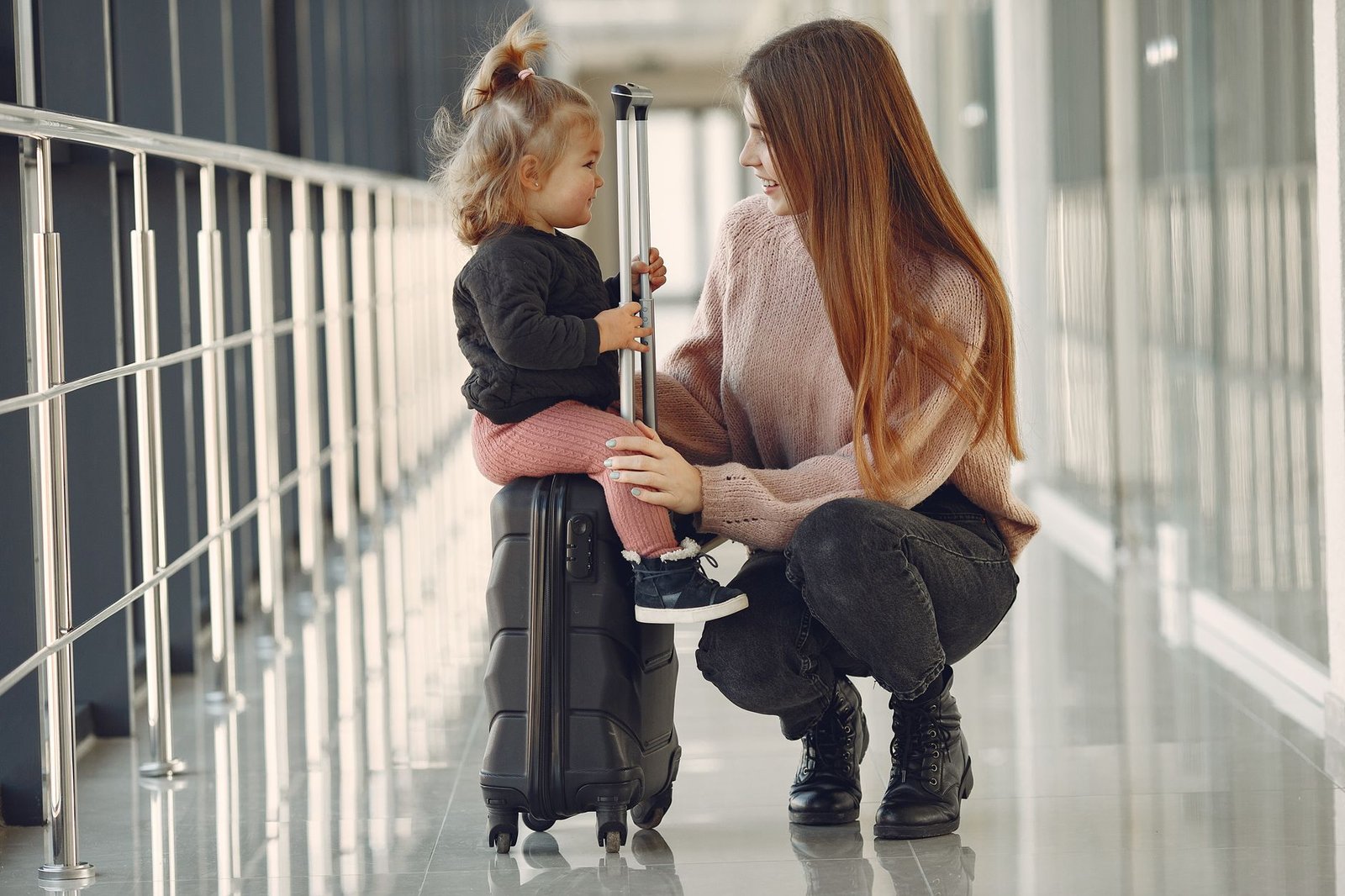 Woman and child waiting with a suitcase at the airport