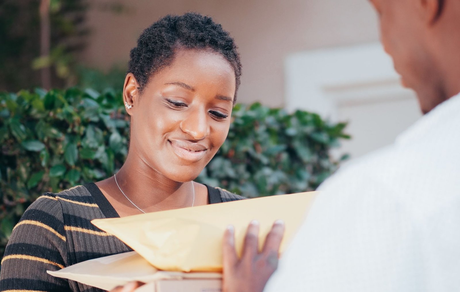 Smiling woman receiving a package from a courier