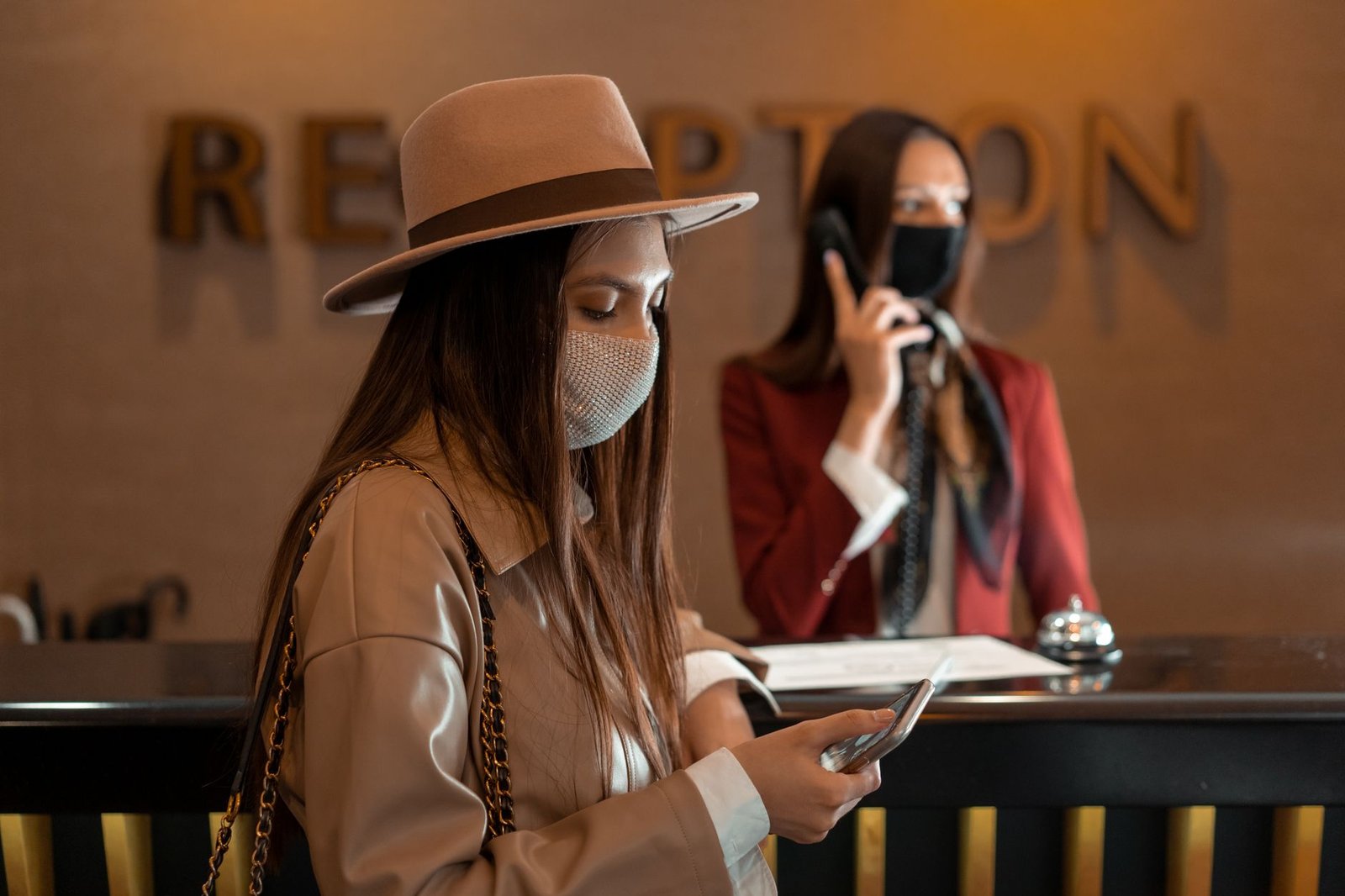 Hotel guest checking booking details on her phone at the front desk