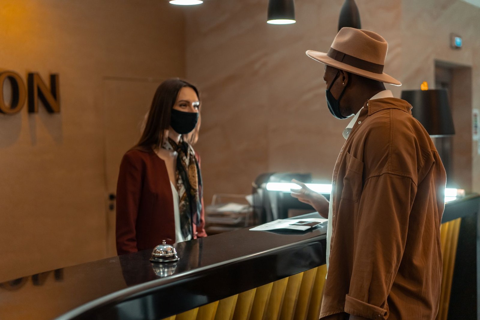 A guest confirming booking details at a hotel reception desk.