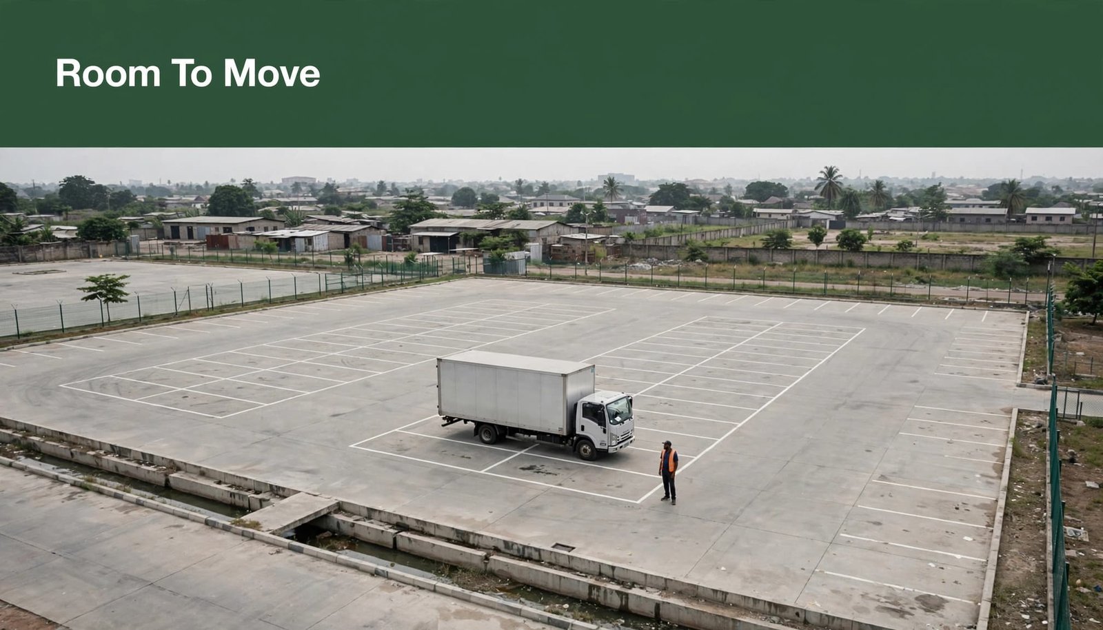 A truck and driver in a marked parking bay beside a drainage channel.