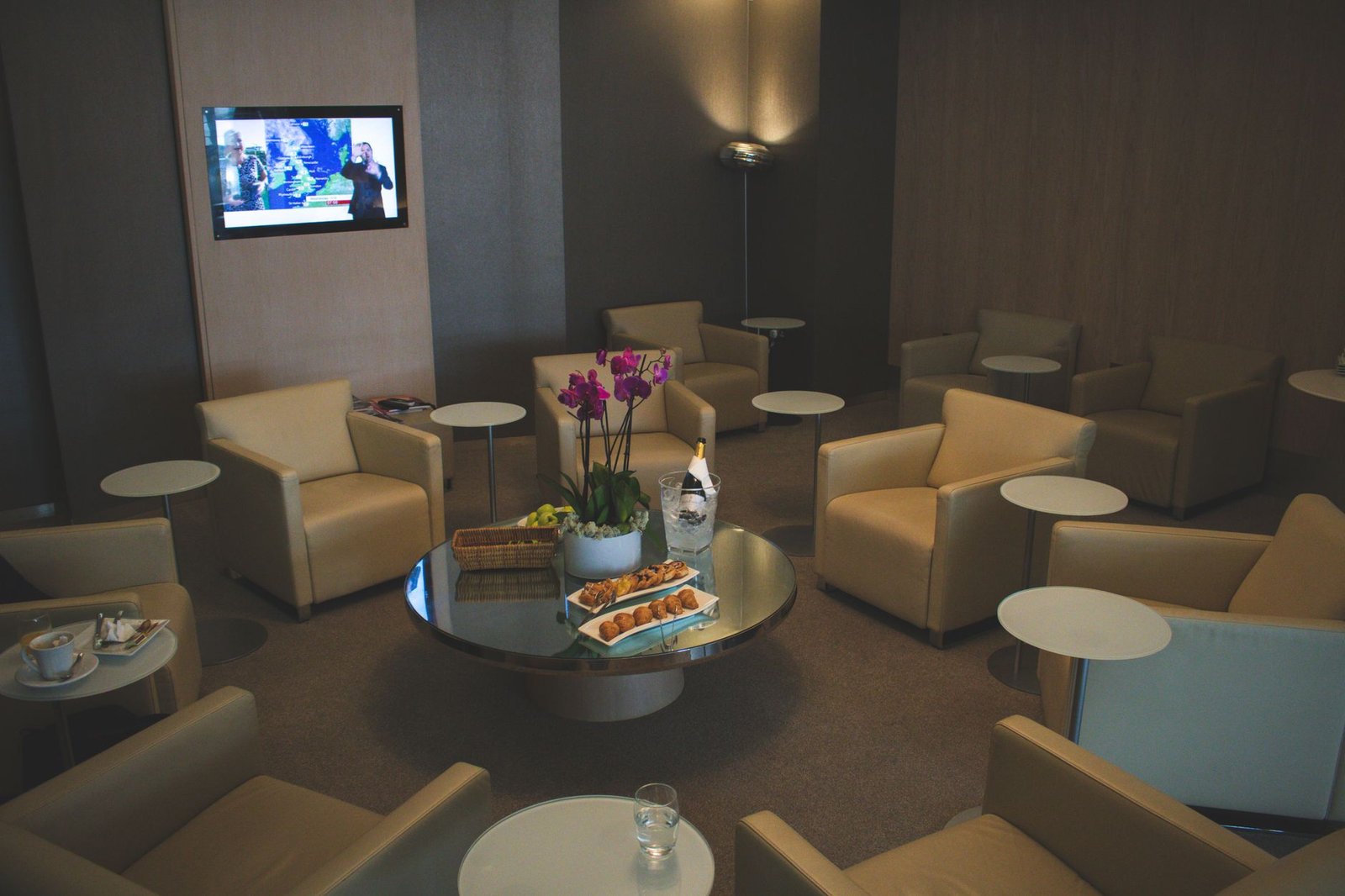 Elegant airport lounge with beige leather seats and orchid decor